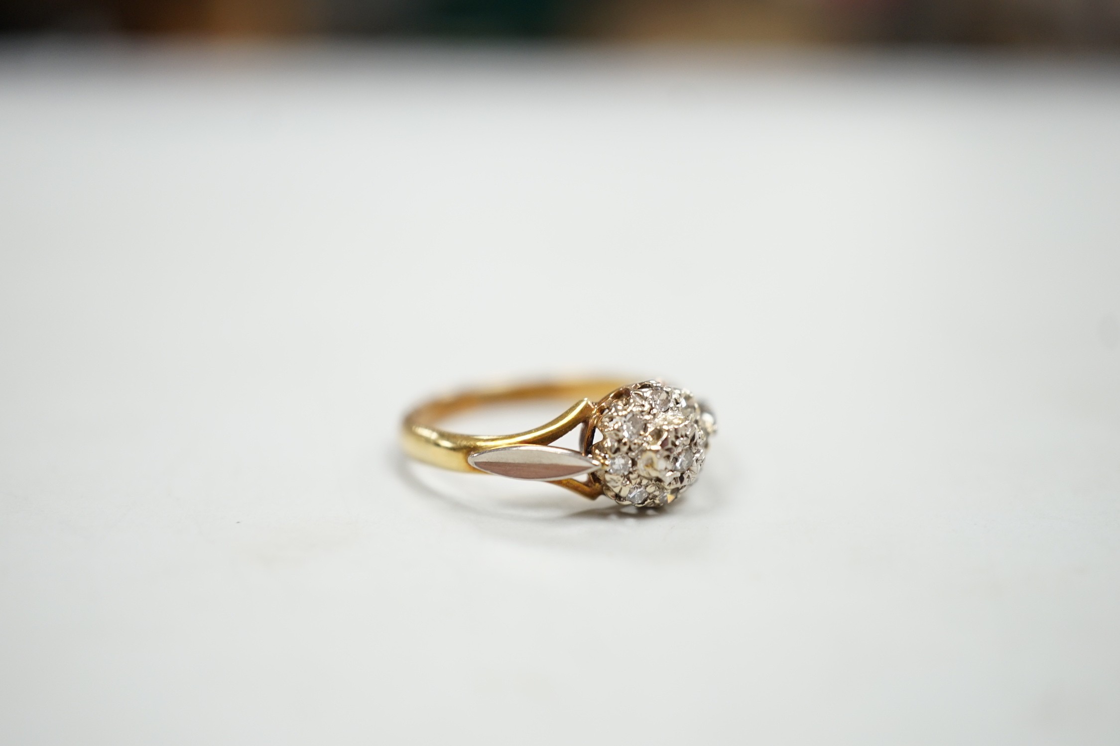 An 18ct and diamond cluster set ring, size K, gross weight 2.4 grams.